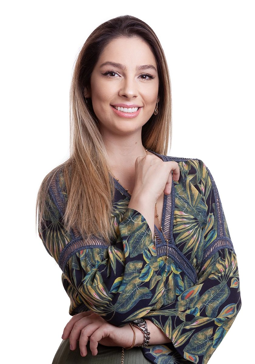 Dentista com blusa florida, em estúdio no Alto da Lapa, São Paulo. Luz suave para valorizar o rosto, feito para posicionamento no LinkedIn e no site.